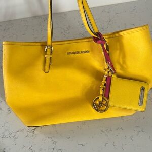 Michael Kors tote bag with two MK charms or key chains .